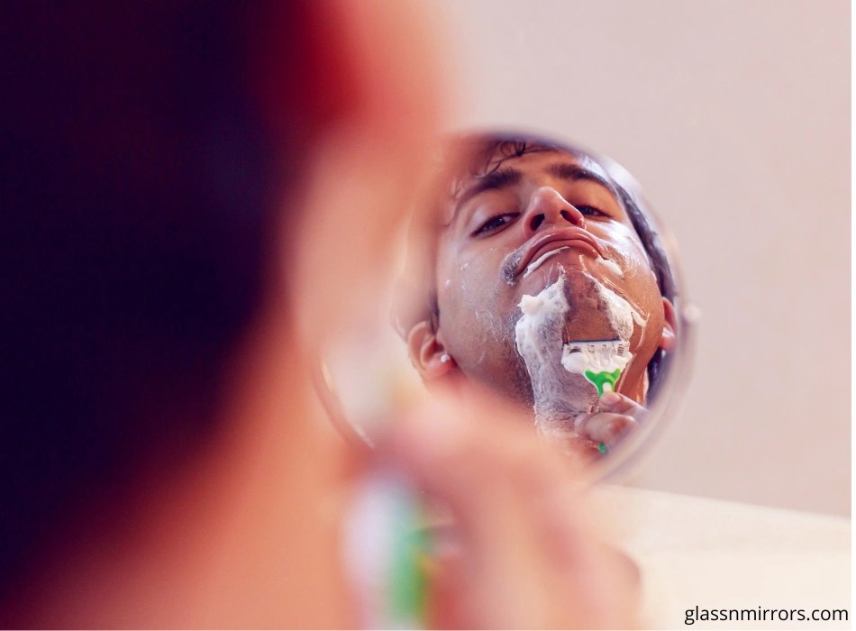 Man shaving in vanity mirror